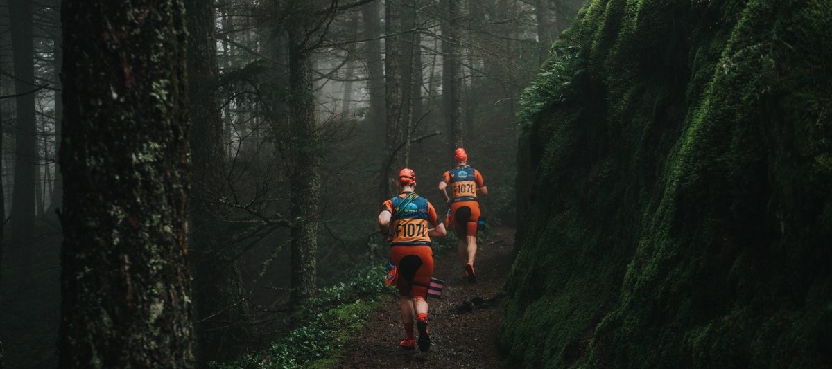 two swimrunners running in forest trail
